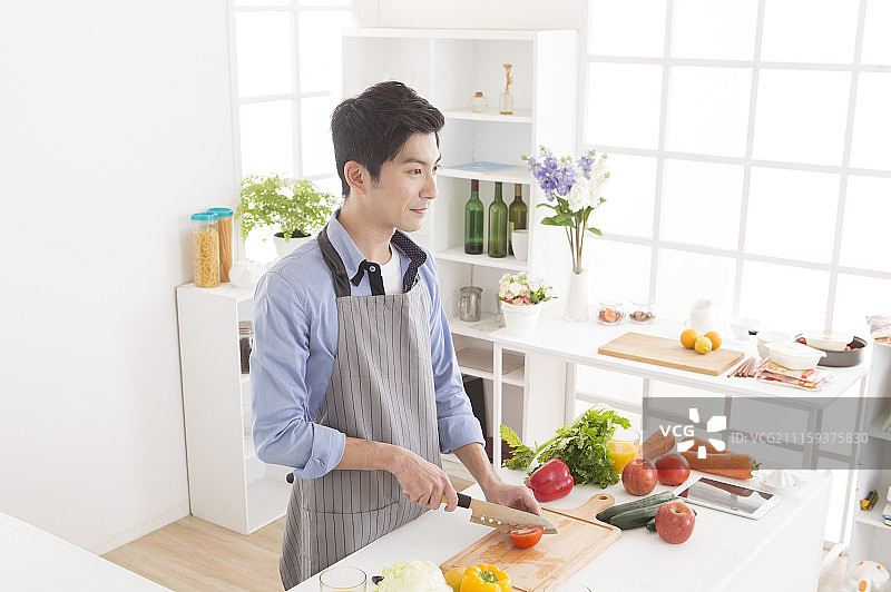 中年男人在厨房切蕃茄图片素材