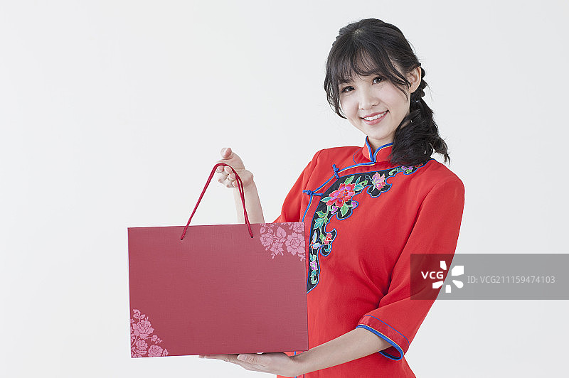 年轻女人穿旗袍送礼图片素材