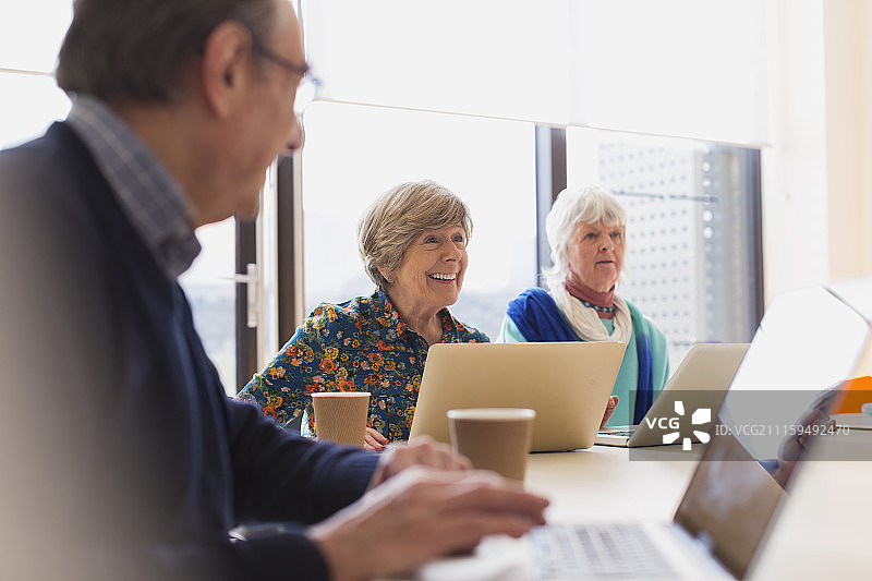 在会议室开会时使用笔记本电脑的年长女商人图片素材