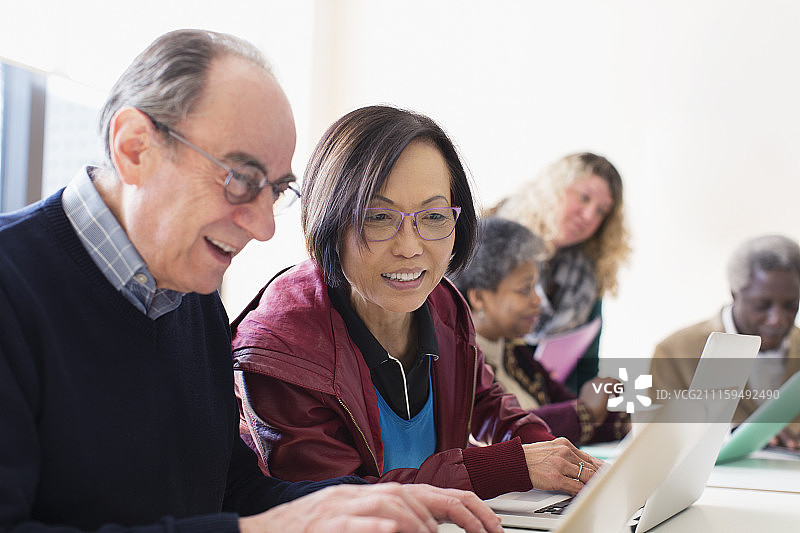 在会议室使用笔记本电脑的老年商人图片素材