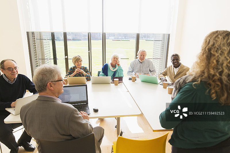 在会议室使用平板电脑和笔记本电脑的年长商务人士图片素材