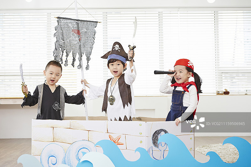 两个小男孩打扮成海盗在船上玩海盗游戏的摄影照片图片素材