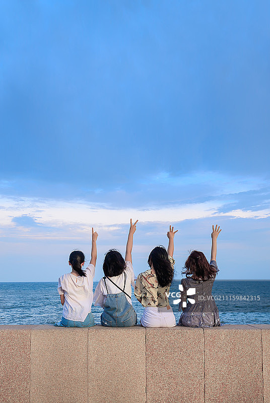 海边坐在一起的少女图片素材