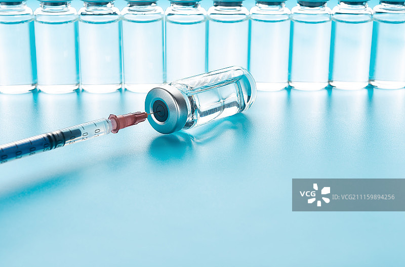影棚拍摄针筒及疫苗蓝色背景图片素材