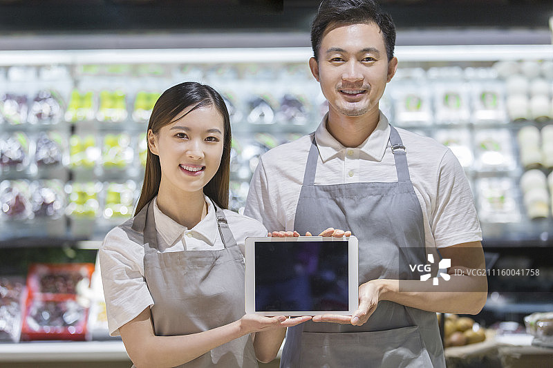 超市工作人员展示iPad图片素材