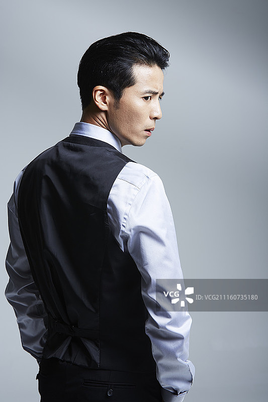 男人穿西装站着回头看的照片图片素材