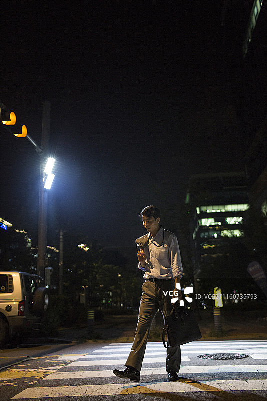 摄影作品：疲惫的男商人夜晚过马路图片素材