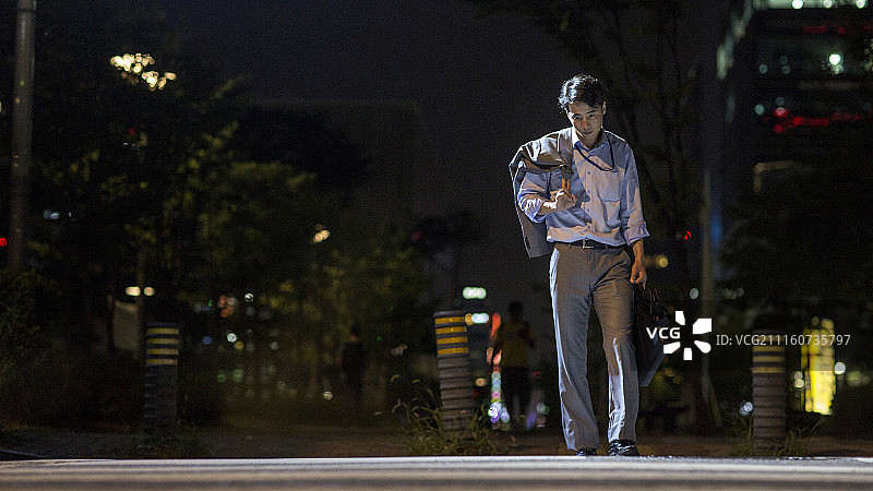 摄影作品：疲惫的男商人夜晚过马路图片素材