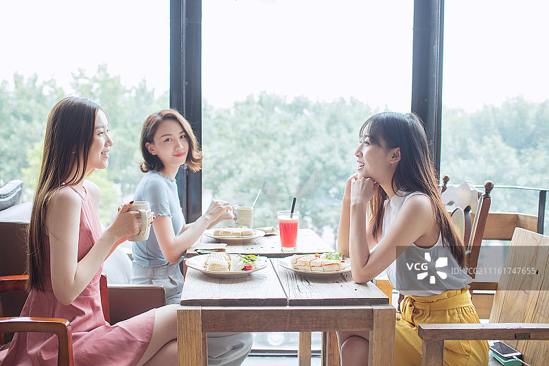 年轻闺蜜在家喝下午茶图片素材
