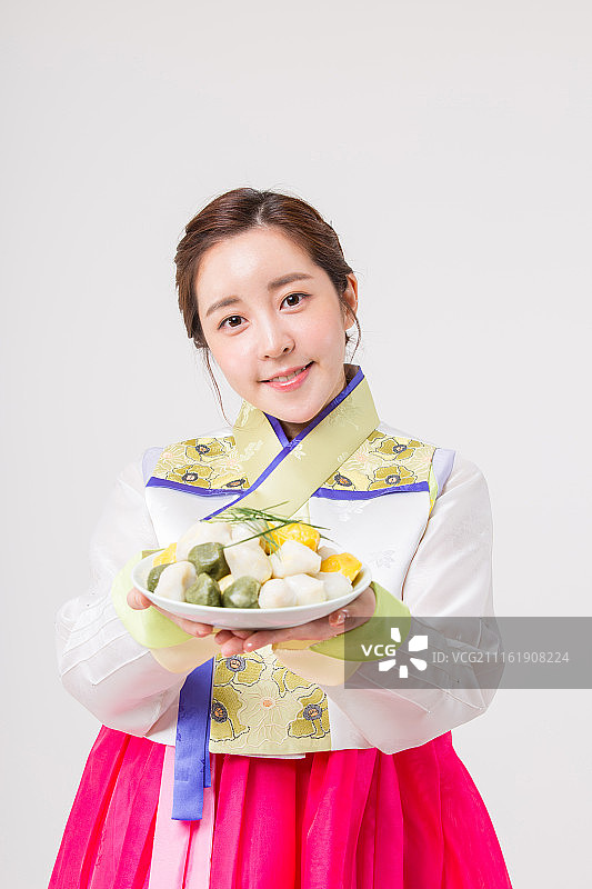 身穿韩服（韩国传统服饰）手持松糕的韩国女子图片素材