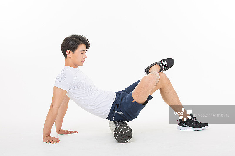 使用泡沫轴做伸展运动的韩国男人图片素材