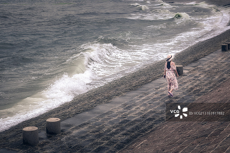 在海边行走的戴草帽女孩图片素材