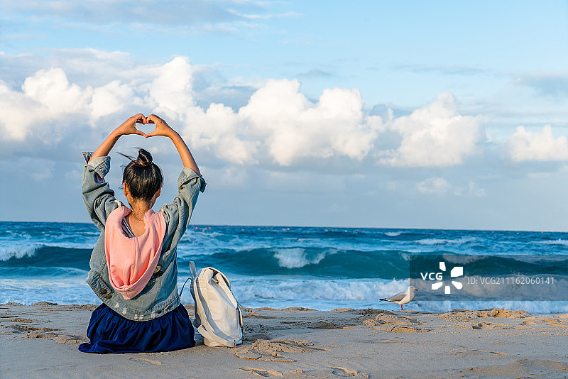 海滩比爱心的少女图片素材