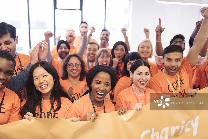 快乐的黑客们举着banner欢呼，在编程马拉松上为慈善事业编码图片素材