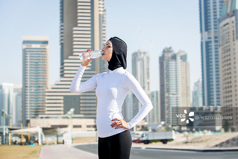 慢跑后喝水的年轻女人图片素材