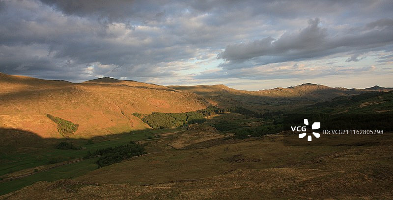 日落时分，多云天空下的丘陵景观美景图片素材