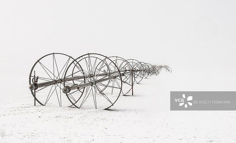 暴风雪天气中留在户外的农业设备图片素材