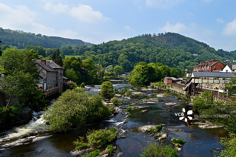 城镇河流与背景中的森林山丘图片素材