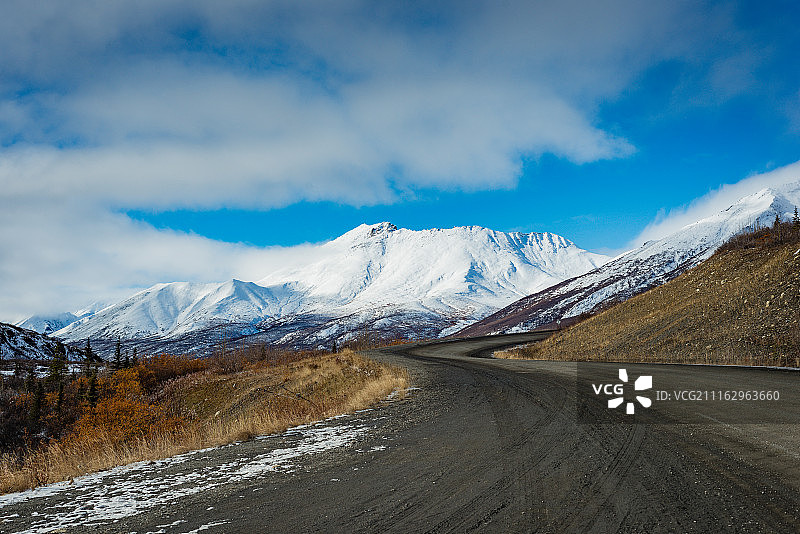 土路和背景中被雪覆盖的山脉图片素材