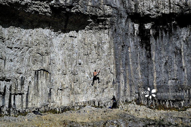 男人攀登悬崖，位于英国约克郡马勒姆图片素材