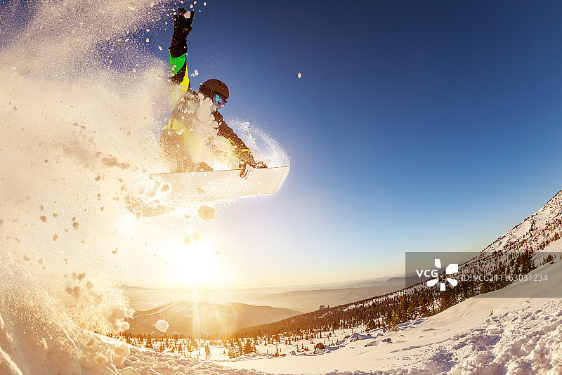 滑雪者在夕阳下跳跃图片素材