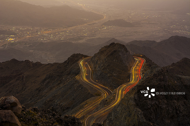 山路夜景，背景为城市灯光图片素材