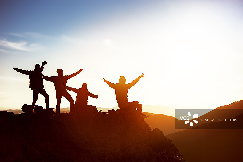 四名游客在山顶庆祝图片素材