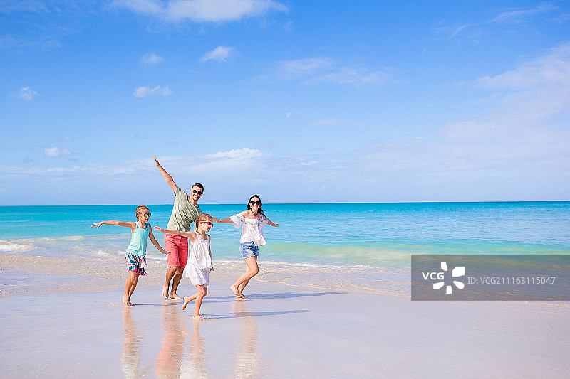 四口之家在海滩度假，奔跑嬉戏图片素材