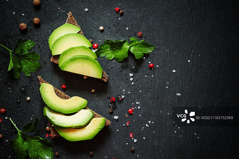 深色背景上的牛油果与香料图片素材