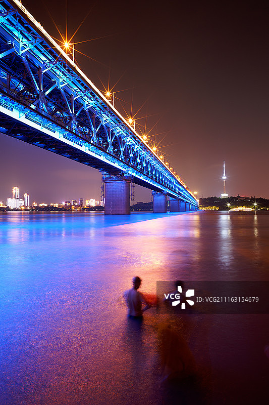 两人在夜晚的河中行走图片素材
