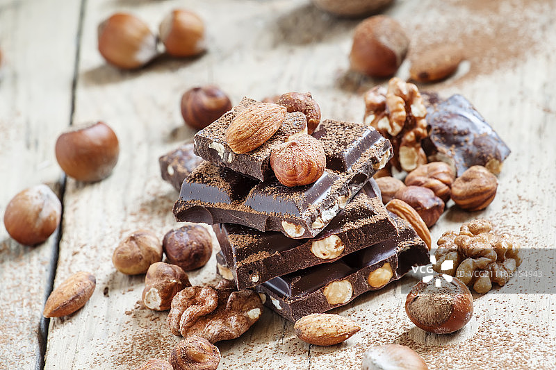 阳光下带坚果的巧克力堆叠特写图片素材