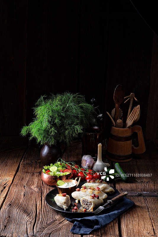 传统肉馅饺子配莳萝和木制餐具拼盘图片素材