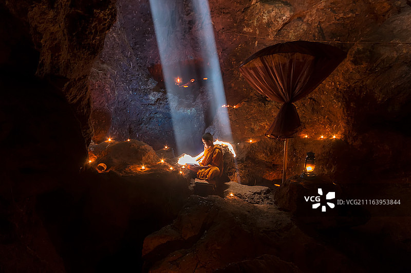 阳光照耀下在寺庙里看书的佛教僧侣图片素材