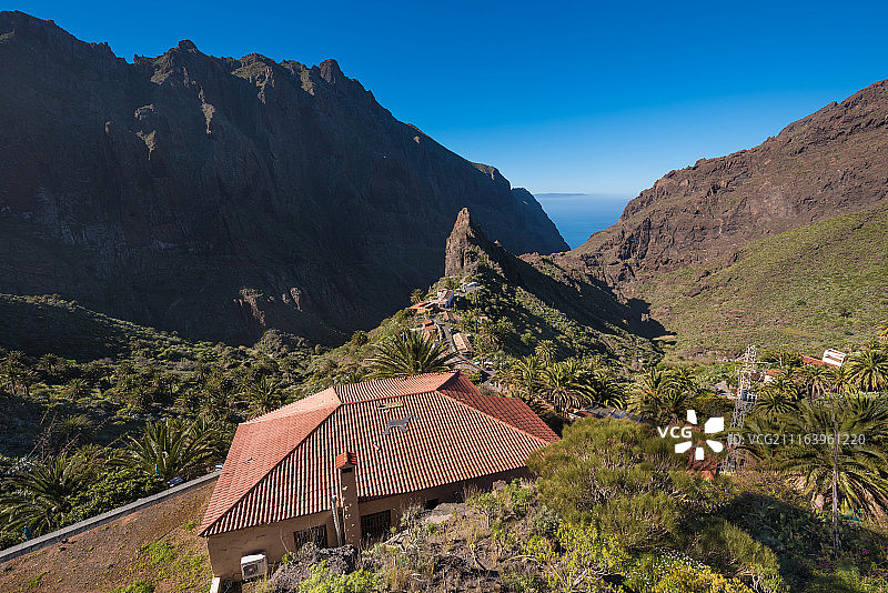 阳光明媚的日子里，有房子的山景图片素材