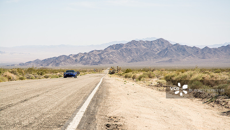在约书亚树国家公园道路上行驶的跑车图片素材