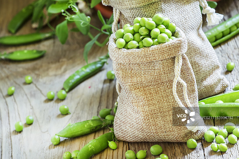 木桌上帆布袋里的青豌豆图片素材