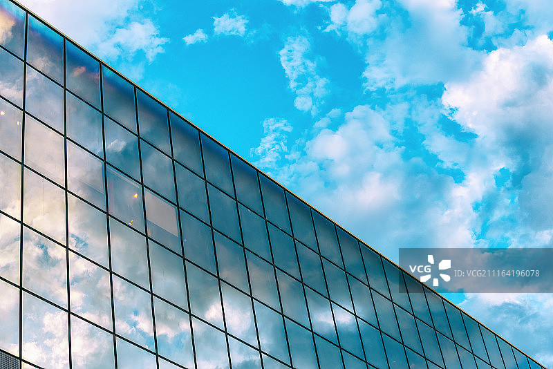 蓝天下反光洁净的现代建筑玻璃幕墙图片素材