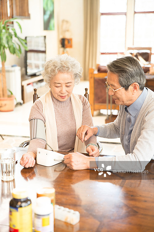 丈夫在为妻子测量血压图片素材
