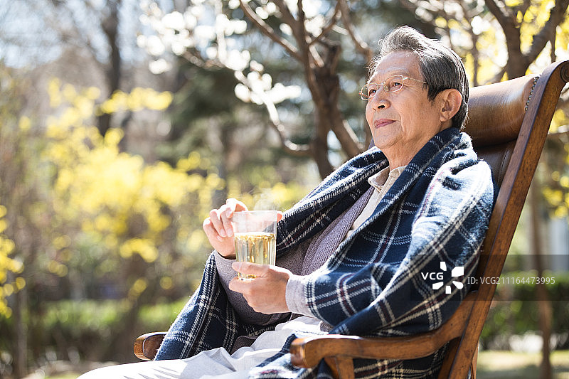 孤独的老年男人在院子里晒太阳图片素材