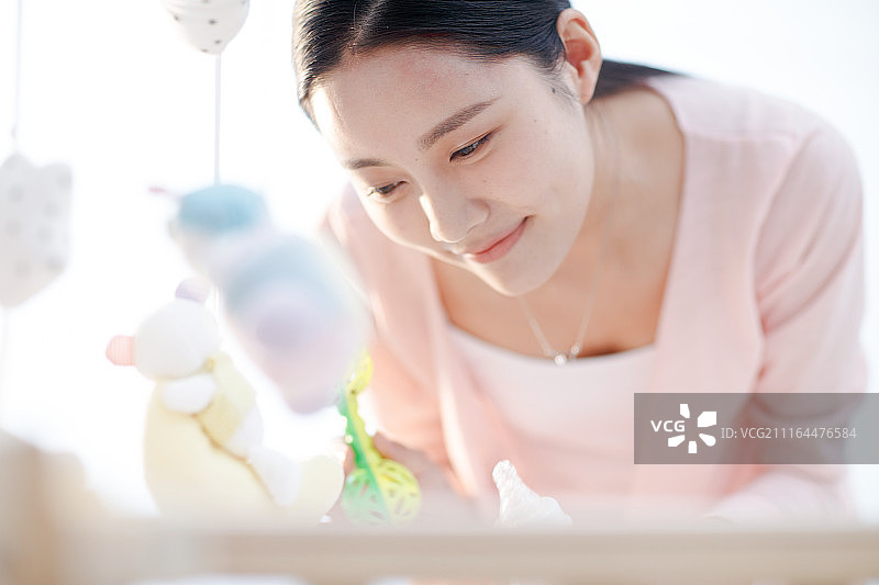 年轻妈妈在婴儿床旁图片素材