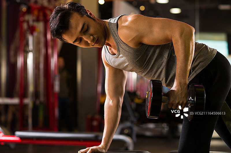 青年男人在健身房里健身图片素材