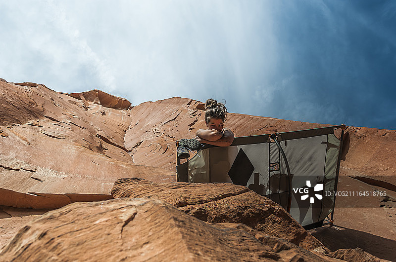 仰视美国锡安国家公园岩壁帐篷中的攀岩女人图片素材