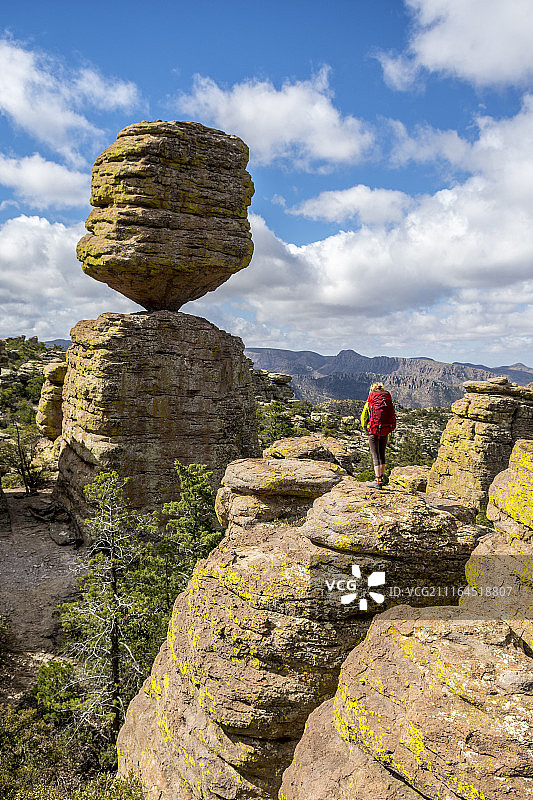在奇里卡瓦国家纪念碑平衡岩旁岩石区徒步的女孩，美国亚利桑那州威尔科克斯图片素材