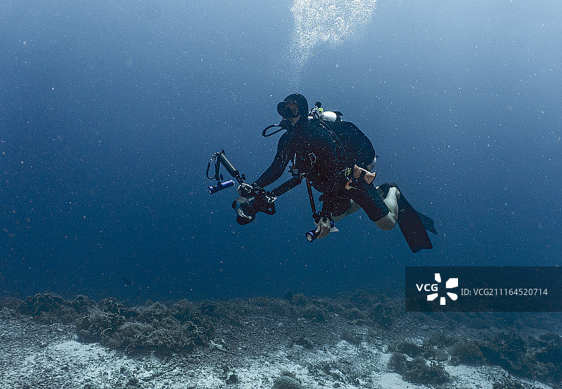 潜水员在菲律宾图巴塔哈礁用电影摄影机拍摄全身照图片素材