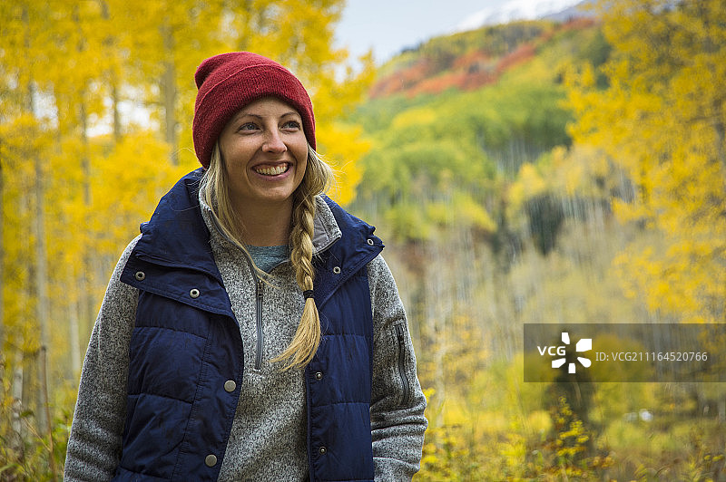 微笑的女徒步旅行者在科罗拉多州阿斯彭树森林中的正面照片图片素材