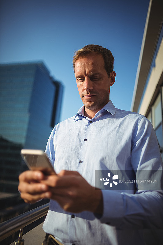 在阳台上使用手机的商人图片素材