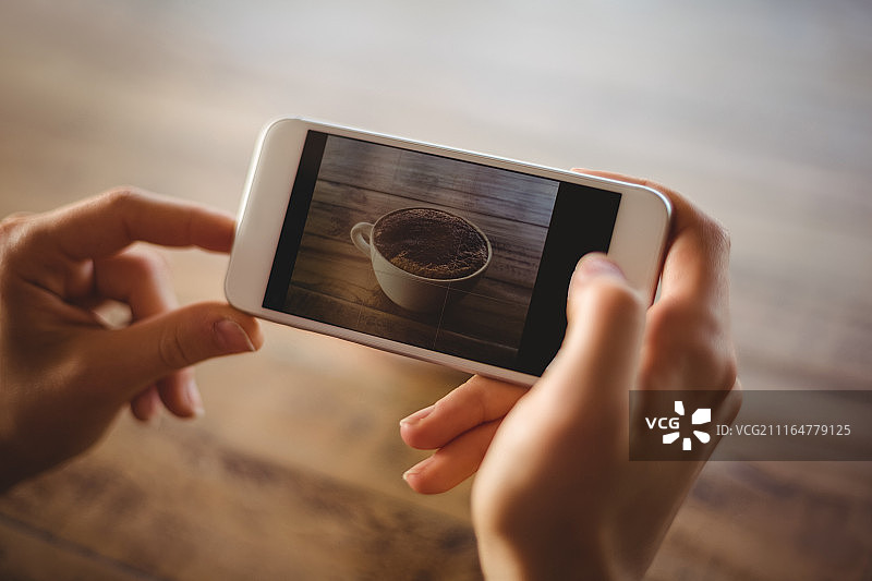 女人拍摄咖啡杯的照片图片素材
