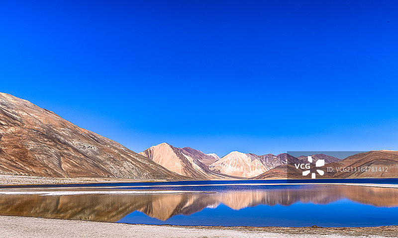 晴空下的湖泊和荒山景色图片素材