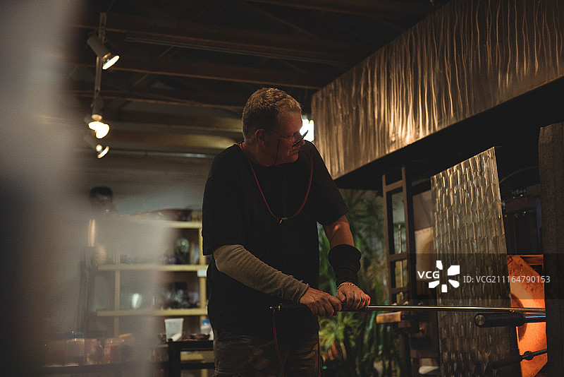 玻璃工匠在熔炉中加热玻璃图片素材