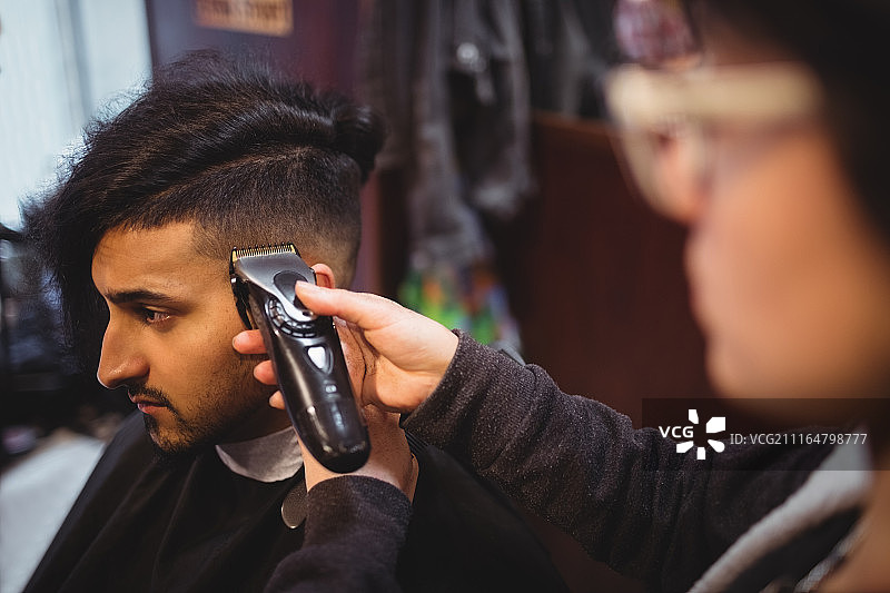 男人用理发器修剪头发图片素材